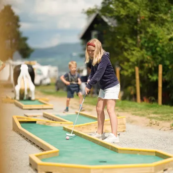 Jente spiller minigolf